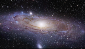 Pemandangan galaksi Andromeda yang menakjubkan dan mendetail, menunjukkan inti pusatnya yang terang dan lengan spiral yang berputar-putar, dikelilingi oleh bintang-bintang yang tak terhitung jumlahnya dengan latar belakang alam semesta yang gelap.
